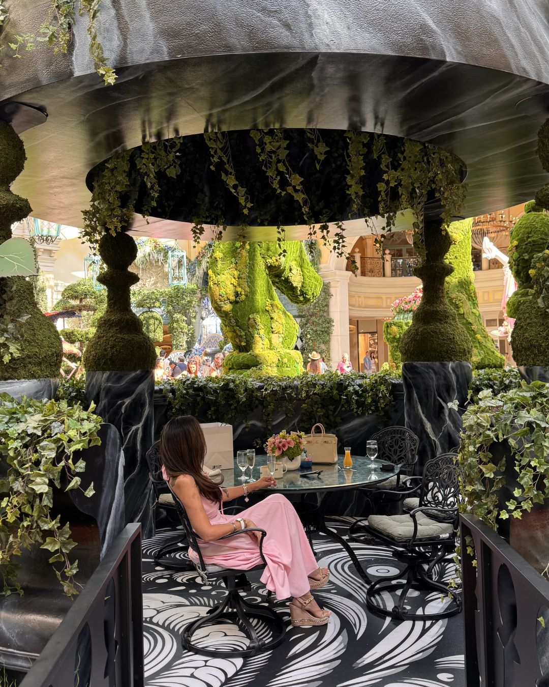 A beautifully set table located directly inside the lush, colorful floral displays of the Bellagio Conservatory.